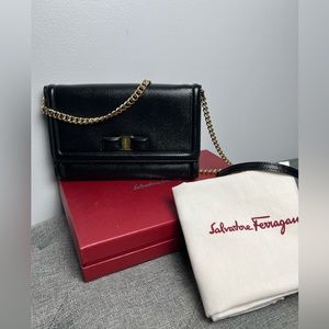 Salvatore Ferragamo Black leather clutch with gold chain .